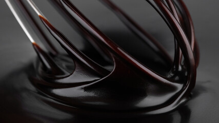 Chocolate. Mixing liquid dark chocolate with whisk. Melted chocolate swirl. Confectioner prepares dessert, sauce