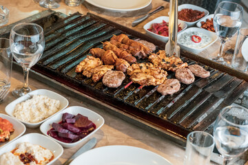 Different types of meat grilled on Barbecue on the table, Served with special Turkish appetizers and Turkish raki.