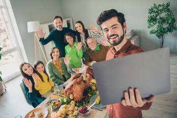 Photo of adorable funny family celebrating thanks giving day sitting table talking modern device...