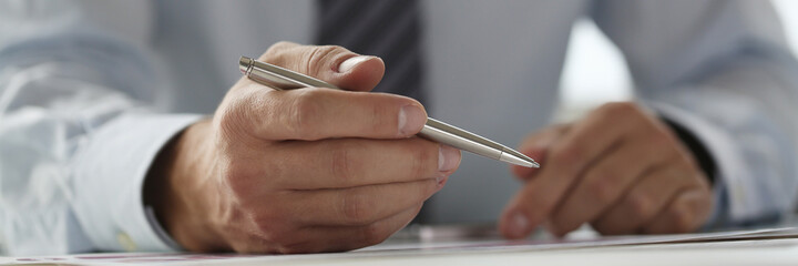 Hand of businessman in suit filling and signing with
