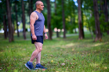 Man running in nature through the park, sports in the city.