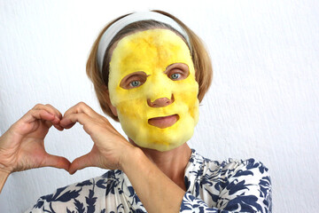 Bubble face mask with charcoal oxygen purifying product on the face of beautiful woman. Mature woman 50s with face mask skin care treatment.
