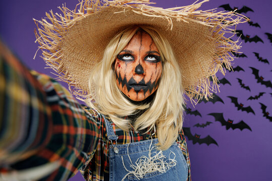 Close Up Young Woman With Halloween Makeup Mask In Straw Hat Scarecrow Costume Do Selfie Shot Pov Mobile Phone Look Overhead Isolated On Plain Dark Purple Background Studio Celebration Party Concept.