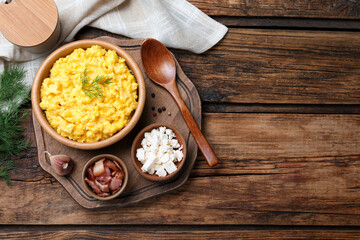 Traditional Ukrainian banosh served with brynza and pork cracklings on wooden table, flat lay....