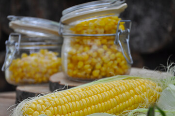 Corn. Frozen corn in a glass jar. Harvesting vegetables for the winter.
Canned sweet corn in a glass jar, fresh and boiled corn on the cob.