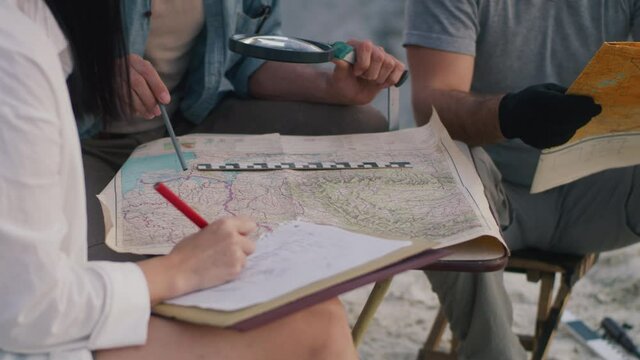 Crop archaeologists reading maps and sketching