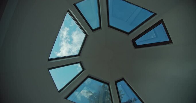 timelapse of clouds through the round window of a private house, a unique view through the ceiling to the sky