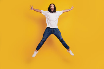 Portrait of funky sportive positive guy jump make star shape on yellow background
