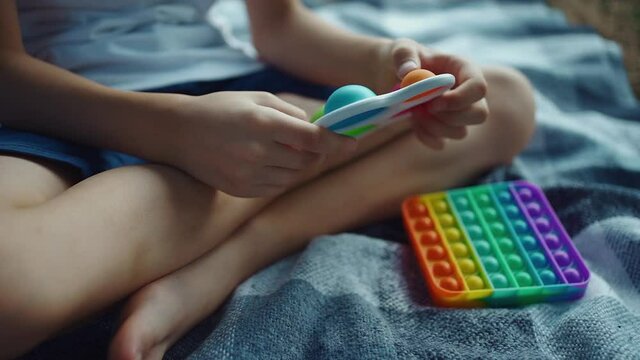 closeup of child hands playing with simple dimple or pushing antistress toy