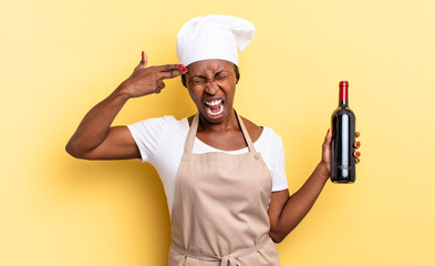 black afro chef woman looking unhappy and stressed, suicide gesture making gun sign with hand,...