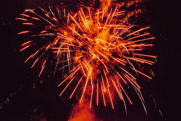 Bright burst of fireworks, flying sparks, colored smoke on black sky. Festive background