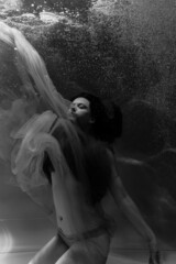Black and white photographs where a beautiful girl poses in the water. She looks like a mythical...