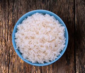 rice in blue bowl on wood