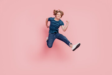 Fototapeta na wymiar Portrait of casual stylish confident guy jump run sport concept fitness on pink background