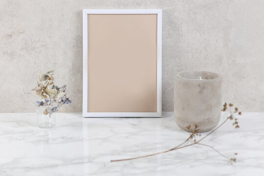 Empty picture frame ,dry flowers an candle. Minimalist style home interior decoration. Simplicity concept. Copy space image.