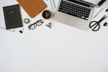 Aesthetic minimalist home office desk workspace on white background with blank copy space. Notes sheet, laptop computer, tablet pad, stationery. Business, work concept for blog, website, social media