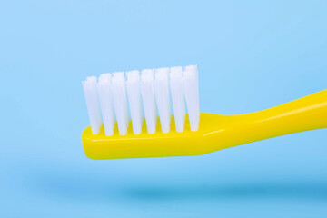 Toothbrush. Yellow toothbrush on a blue background. A yellow toothbrush with white bristles. Oral...