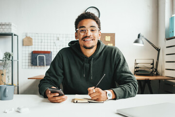 Investing in stock exchange market. Portrait of black casual man working using mobile phone app