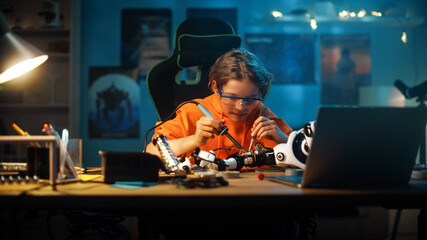 Smart Young Teenage Schoolboy is Studying Electronics and Soldering Wires and Circuit Boards in His Science Hobby Robotics Project. Kid is Working on a Robot in His Room. Education Concept.