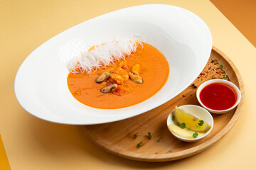 Traditional soup tom yam. In a plate on a light background.