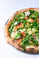 Pizza with mozzarella, salmon slices, fresh arugula. Isolated on white background. Italian cuisine concept