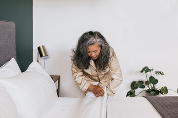 Asian woman making bed in the morning