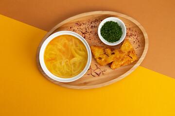 Traditional noodle soup. In a plate on a colored background.