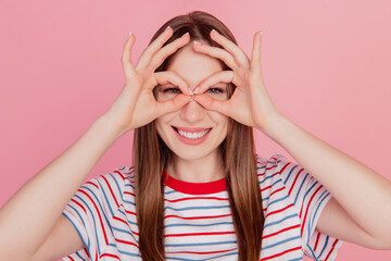 Portrait of charming sweet funky lady fingers show okey sign binoculars form on pink background