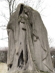 Mourning sculpture of two women dressed in capes in the Pere Lachaise cemetery. All Saints Day, November 1, Day of the Dead, Dia de muertos.