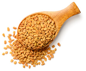 fenugreek seeds in the wooden spoon, isolated on the white background, top view