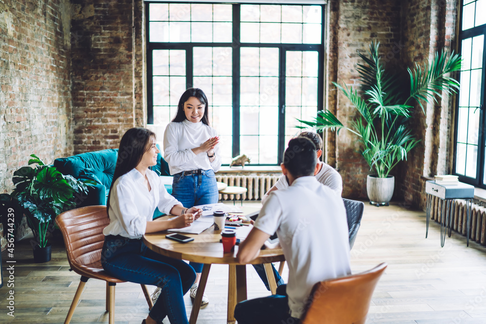 Poster smiling multiethnic coworkers in stylish loft office