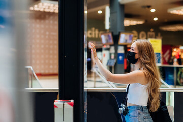 Young caucasian woman indoor pointing ticketing using automated touch screen machine