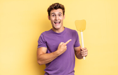 looking excited and surprised pointing to the side and upwards to copy space. kill flies concept