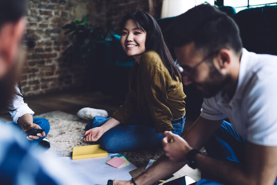 Group of happy architects discussing project ideas during collaborative meeting for friendly brainstorming in coworking space, portrait of cheerful female student enjoying productive exam preparation