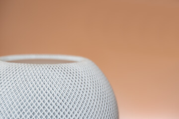 Home equipment - close up of smart speaker in foreground and blurred background.