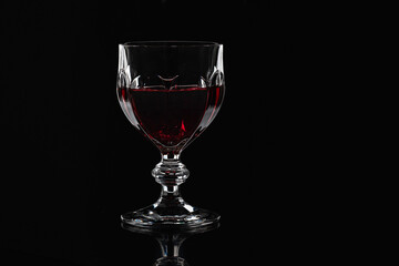 Wine glass with red wine on a black background