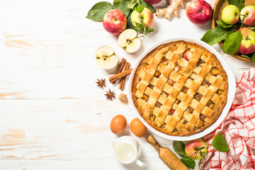 Apple pie. Traditional apple cake with ginger and cinnamon at white wooden table. Top view image with copy space.