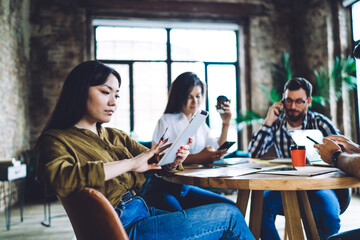Asian female blogger reading education publication browsed on modern touch pad technology, millennial student connecting to 4g wireless internet on digital tablet for searching network website