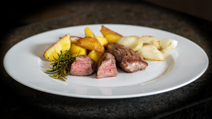 the roasted tenderloin from the red deer calf with fries potatoes and roasted onions is a delicious...