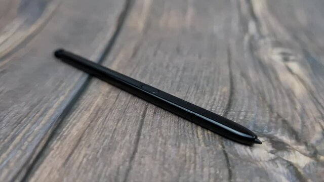 The Black stylus from a mobile device. Digital stylus close-up.