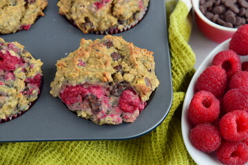 Freshly baked raspberry banana chocolate chip muffins on muffin pan