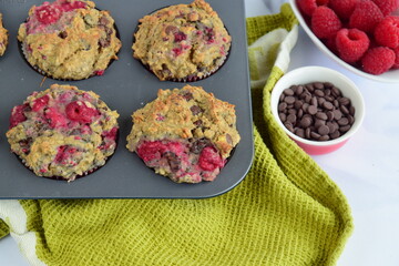 Freshly baked raspberry banana chocolate chip muffins on muffin pan