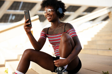 Beautiful African woman with roller skates. Urban sexy girl having fun outside.