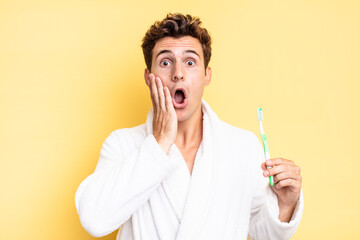 feeling shocked and scared, looking terrified with open mouth and hands on cheeks. tooth brush concept