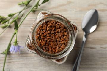 Jar of chicory granules on white wooden table, top view