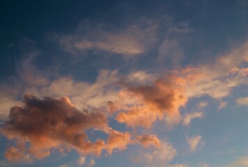 Naklejka na ściany i meble Pink clouds. Pink clouds on a background of blue sky at sunset. Background image.