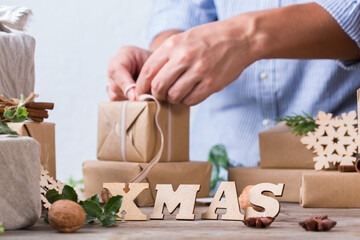 Obraz na płótnie Canvas Zero waste Christmas concept, male hands wrapping gifts