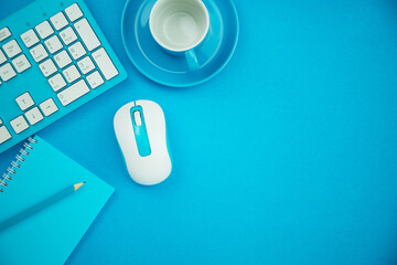 Office desk table of Business workplace and business objects of mouse keyboard paper note and coffee cup on blue background