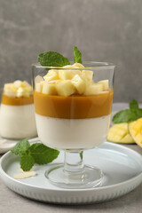 Delicious panna cotta with mango on grey table