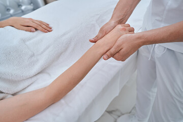 Experienced therapist giving a hand massage to a patient